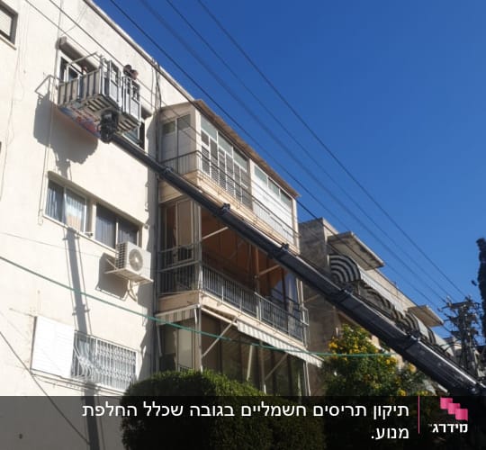 תריסים פתוחים במרפסת בניין עם מנוף